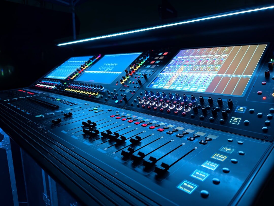 Professional audio mixing console with sliders and knobs in broadcast studio